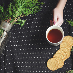 background - tea and biscuits on a dark background and green branch