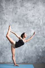 Obraz na płótnie Canvas Young beautiful woman practicing yoga in gym.