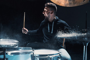Drummer rehearsing on drums before rock concert. Man recording music on drum set in studio