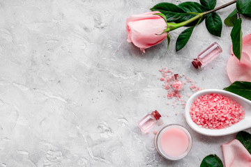 Natural organic cosmetics with rose oil. Cream, lotion, spa salt on grey background top view...