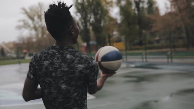 Man rotating ball on finger in basketball court