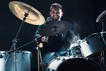 Drummer rehearsing on drums before rock concert. Man recording music on drum set in studio