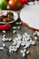 Fototapeta na wymiar Dry white kidney beans on wooden table