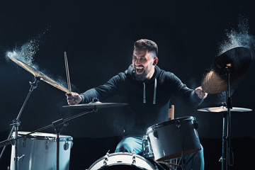 Drummer rehearsing on drums before rock concert. Man recording music on drum set in studio