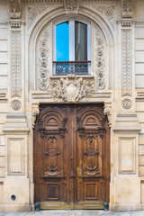 Fototapeta na wymiar Paris, beautiful wooden door, girder with sculptures 