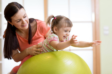 Mother and baby playing with fitness ball