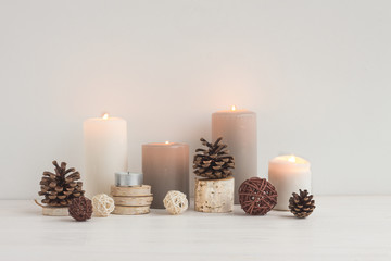 Christmas candles, wood slice decorations, pine cone on white background