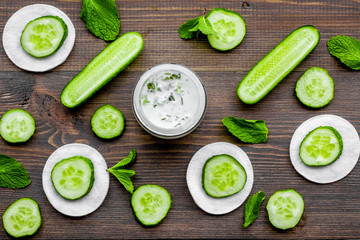 Cucumber moisturising cream or mask pattern. Dark wooden background top view