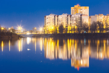 Fototapeta na wymiar Night View Of Urban Residential Area Overlooks To City Lake Or River Park
