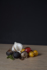 Black Garlic, Regular Garlic, and Tomatoes on Wooden Surface