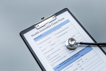 Health insurance for reception at the doctor. Document and stethoscope on dark grey background
