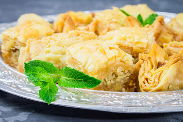 baklava turkish traditional delight on a dark wood background. toning.