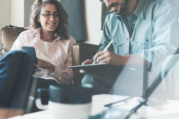 Fototapeta premium Dwóch młodych specjalistów pracujących razem w przytulnej loftowej przestrzeni biurowej. Mężczyzna i kobieta badający plany biznesowe i komunikacyjne. Efekt podwójnej ekspozycji