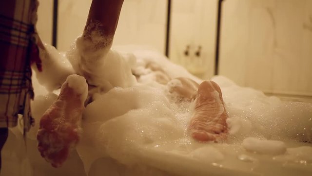 Young woman is lying in a bubble bath in hamman