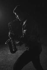 Fototapeta na wymiar Man playing saxophone, with black background