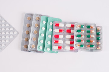 Different medicines. Tablets, pills in blister pack. Medications drugs. Pills over a white background. Medicament treatment. Health care photo.
