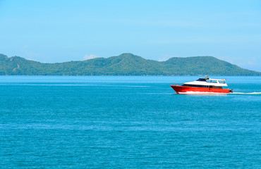 Landscape with red boat and sea under the blue sky in the morning.
