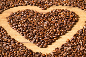 Grains of invigorating coffee on a wooden table