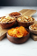 Salty snacks. Pretzels, chips, crackers in wooden bowls.