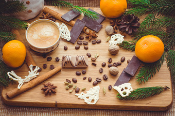 New Year's winter composition with coffee and spices in the kitchen on a wooden dinette and with pine branches. Beauty and inspiration with winter desserts.