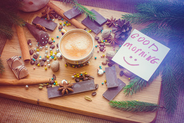 New Year's winter composition with coffee and spices in the kitchen on a wooden dinette and with pine branches. Beauty and inspiration with winter desserts.