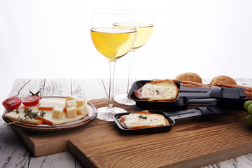 Delicious traditional Swiss melted raclette cheese on diced boiled or baked potato served in individual skillets.