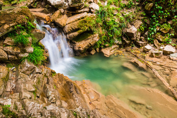 Waterfall and small lake in the ravine Chudo-Krasotka in summer day, Sochi, Russia
