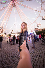 POV shot of boyfriend holding his girlfriend, attractive young blonde woman by hand in front of...