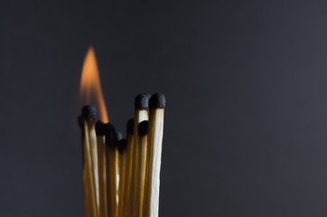 Burning matchstick on black background