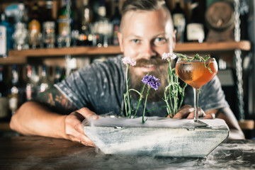 Barman is making cocktail with ice vapor