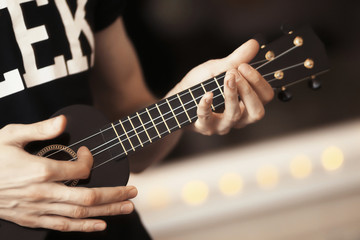 The man plays on the ukulele guitar