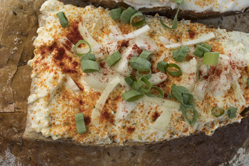A slice of bread with garlic spread and green and white onion
