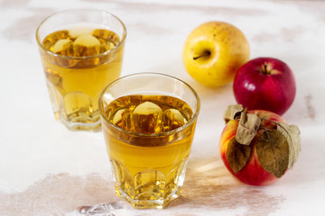 Apple juice in glasses and fresh apples on a wooden background. Rustic style.