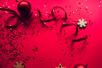 Christmas red glowing decorative balls and ribbons on red toned background. Winter seasonal flatlay, copyspace for text