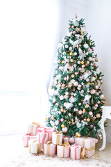 Christmas living room with a Christmas tree, gifts and a large window. Beautiful New Year decorated classic home interior