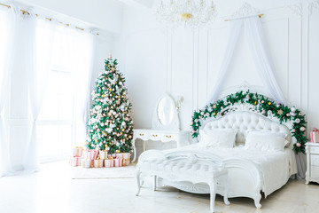 Christmas living room with a Christmas, gifts tree and bed. Beautiful New Year decorated classic home interior. Winter background