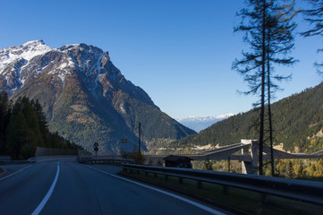 Beautiful road in the Swiss Alps. Mountain peaks covered with snow. Simplon pass
