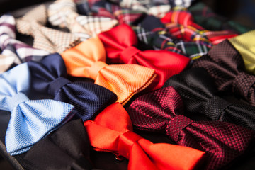 Collection of colorful and varieties of pattern bow ties texture background in the middle on a wooden tray