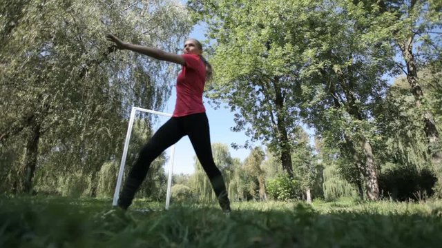 Two girls in the park are engaged in taibo. Two beautiful girls do morning exercises in the park. The concept of a healthy lifestyle.