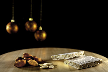 almond nougat with Christmas balls  on wood and  black background