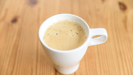 Eine Tasse Kaffee auf einem Holztisch