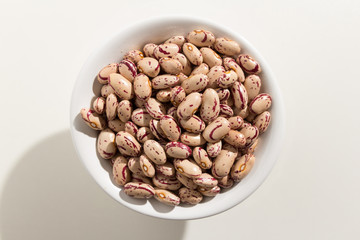 Sugar Bean legume. Top view of grains in a bowl. White background