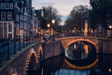 A bridge, canal, and historic houses during twilight blue hour, Amsterdam, Netherlands
