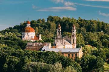 Fototapeta na wymiar Vilnius, Lithuania. View Of Church Of The Ascension And Church Of The Sacred Heart Of Jesus Among Green Foliage.