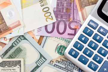 Euro with dollar banknotes and calculator.