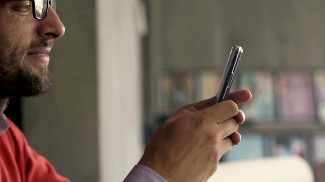 Businessman using smartphone by table in the office
