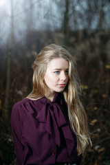 portrait of a blonde at night in the forest. The girl has blue eyes. Vintage Blouse