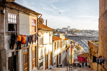 Street view with beautiful old buildings and famous bridge in Porto city during the sunset in Portugal