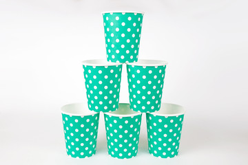 green white polka dots paper cups for drinks, a pyramid on a white isolated background