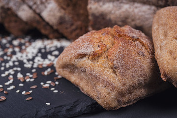 Assortment of baked bread on dark background.